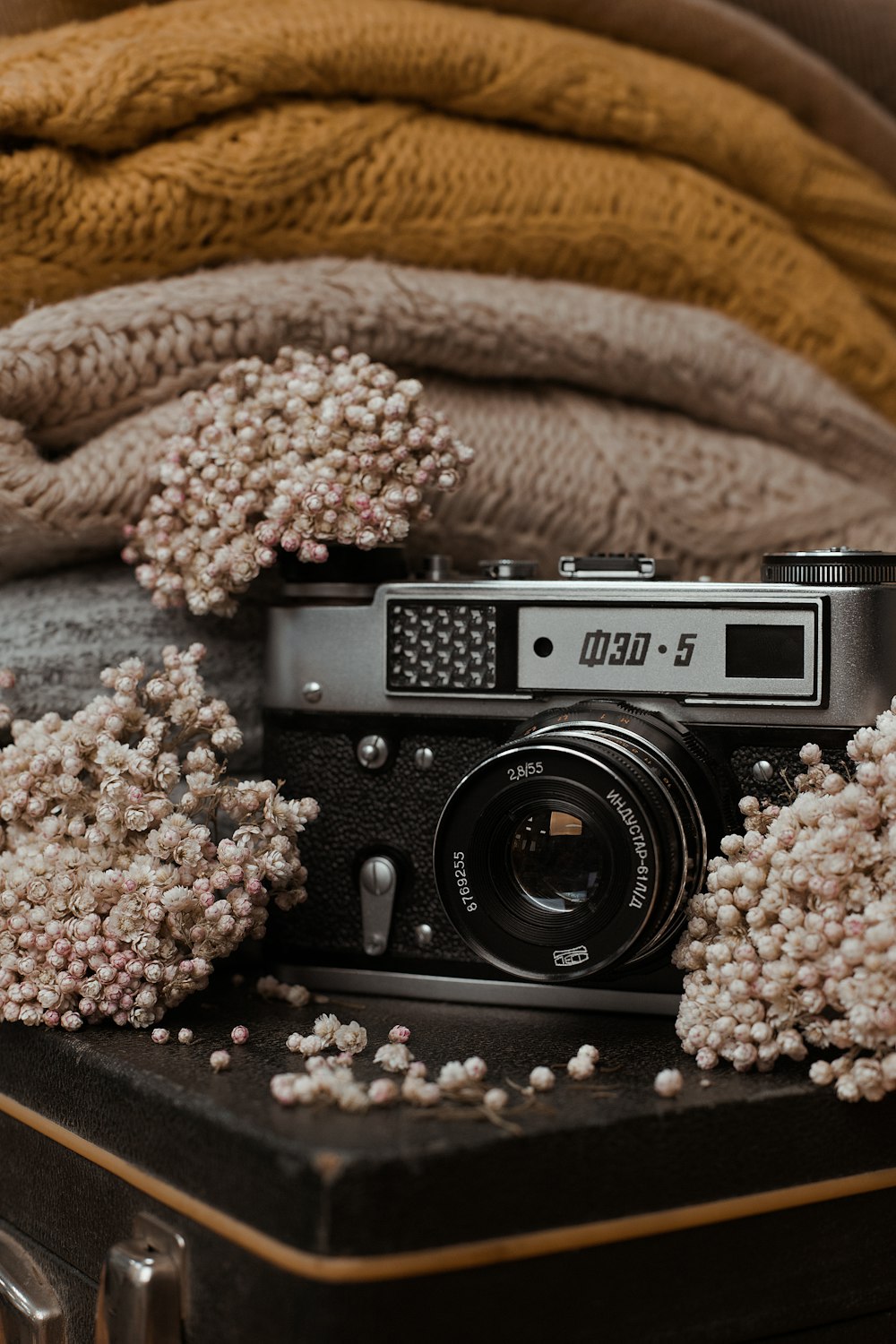 a camera sitting on top of a table next to a pile of blankets