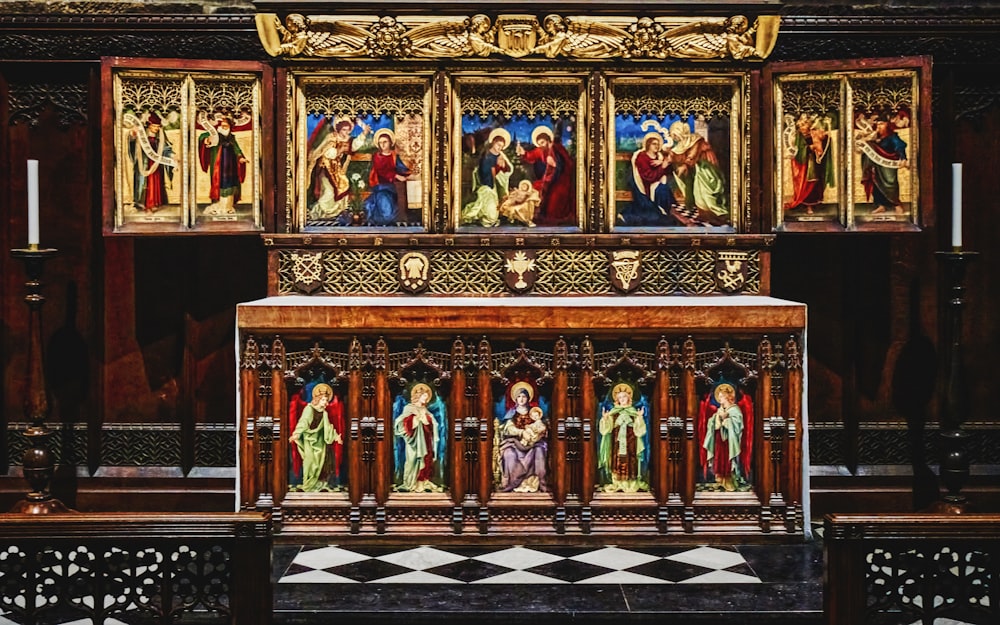 ein hölzerner Altar mit Gemälden darauf in einer Kirche