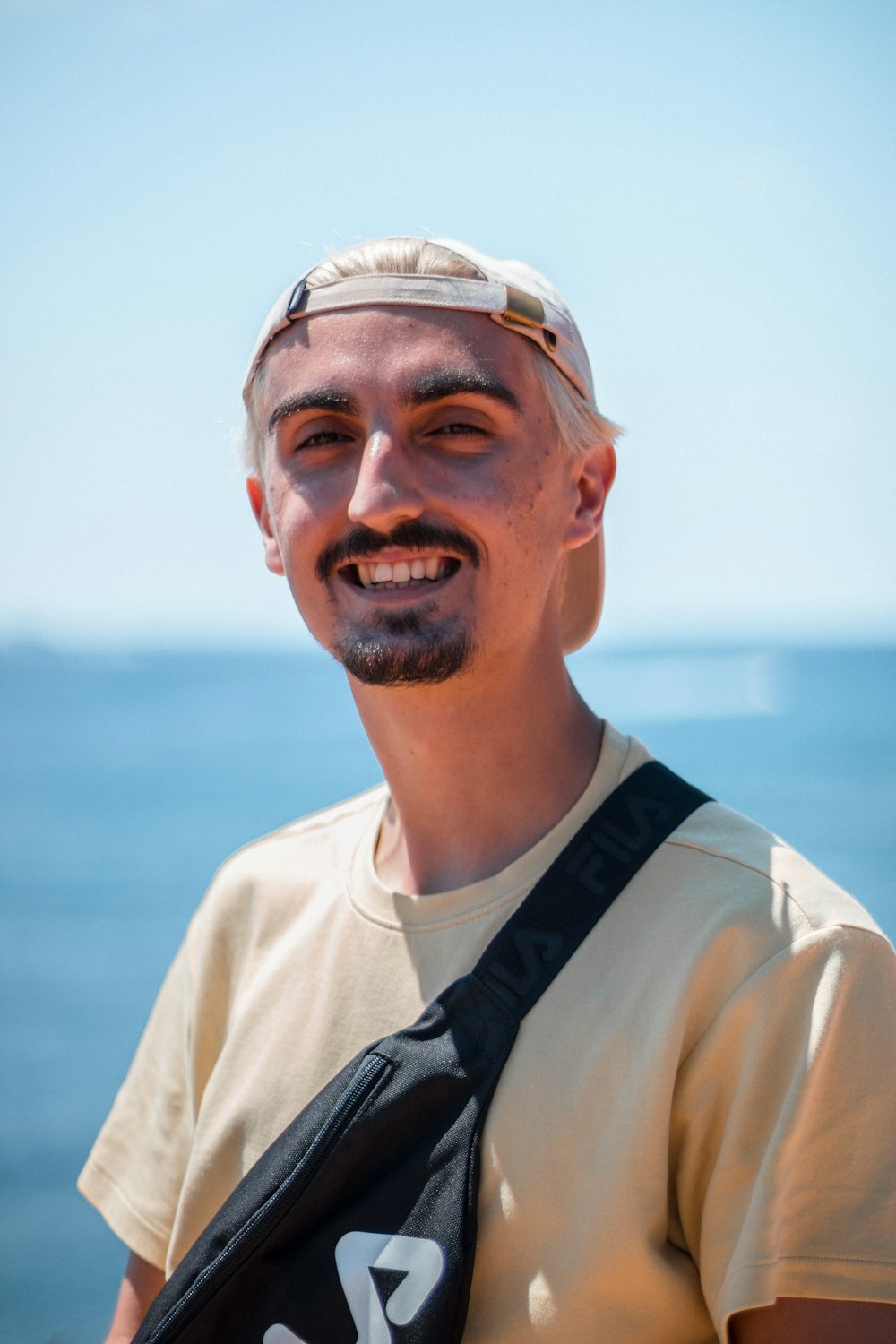 a man with a hat and a camera bag