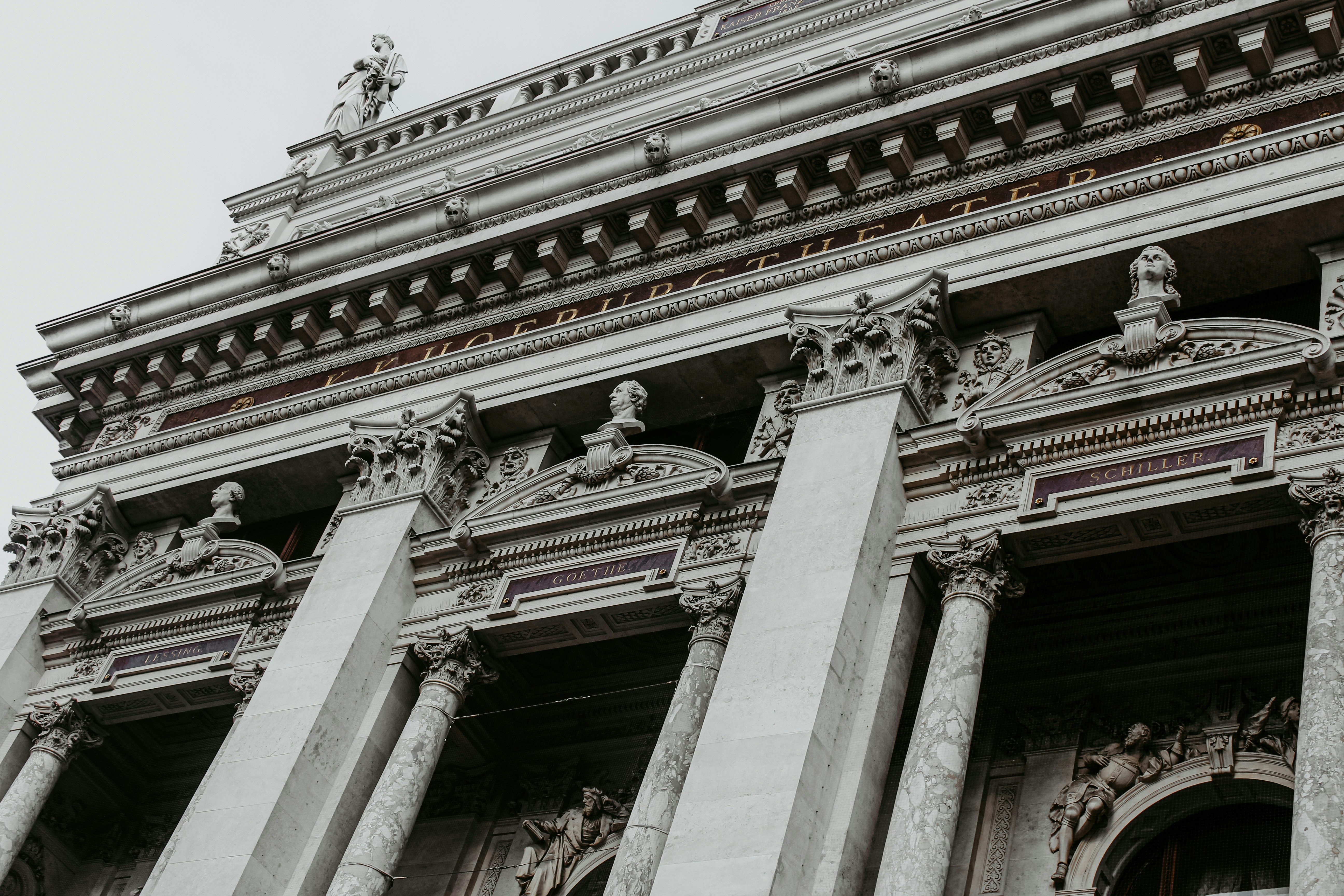 a tall building with columns and statues on top of it