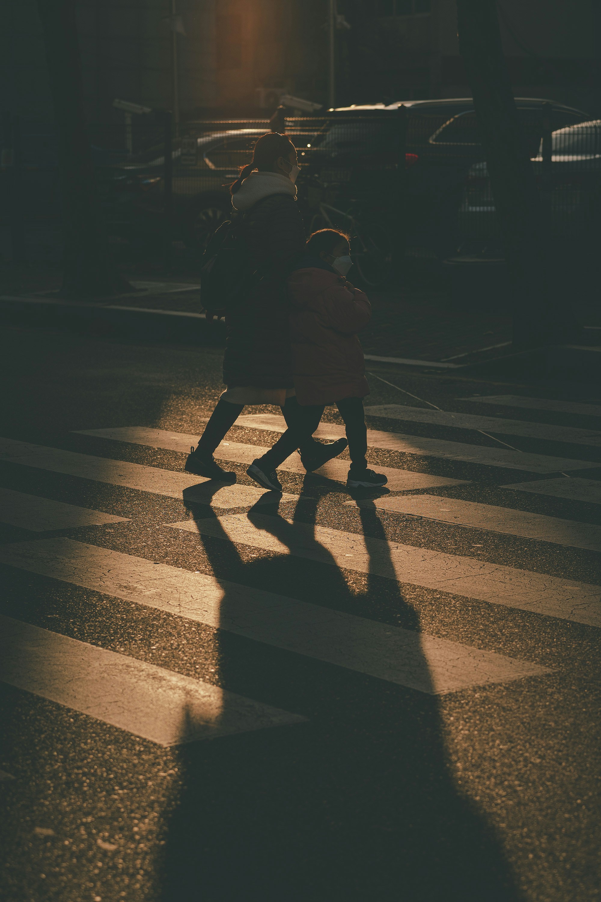 a couple of people walking across a street
