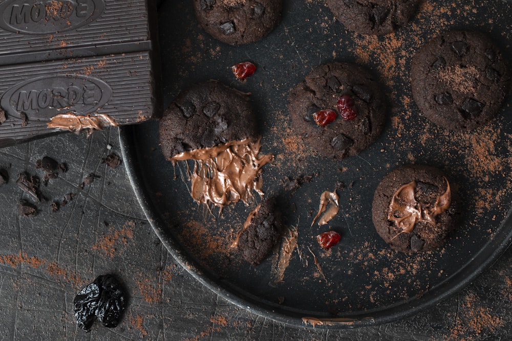 a plate of chocolate cookies with a bite taken out of one