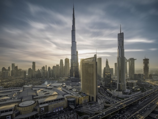 A vibrant street scene in Dubai with a mix of modern skyscrapers and traditional souks under a bright blue sky.