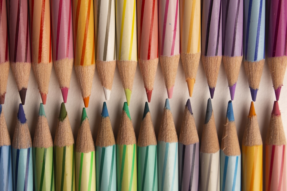 a group of colored pencils lined up on a wall