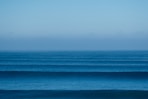 a large body of water sitting under a blue sky