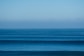 a large body of water sitting under a blue sky