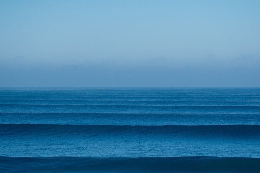 a large body of water sitting under a blue sky