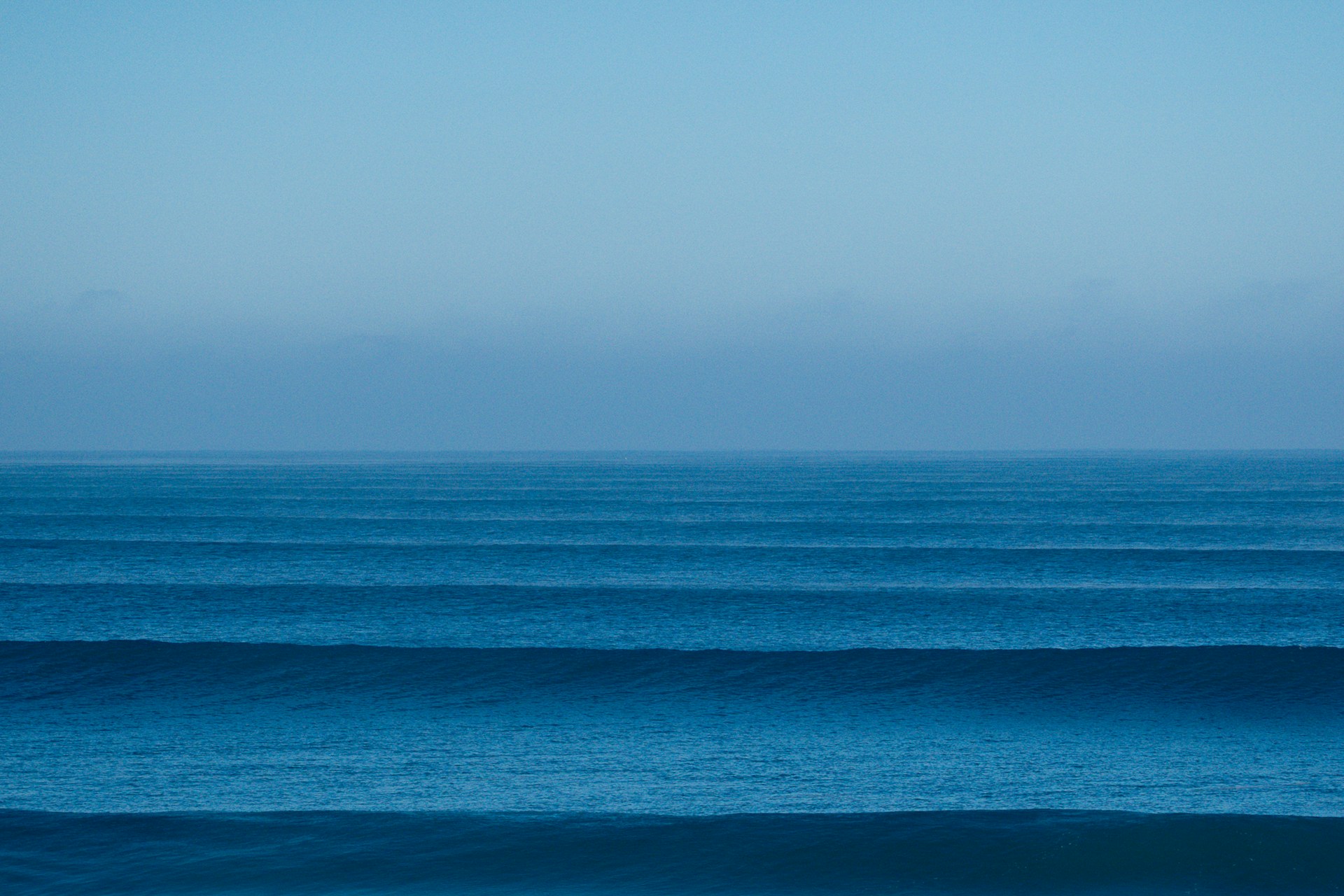 a large body of water sitting under a blue sky