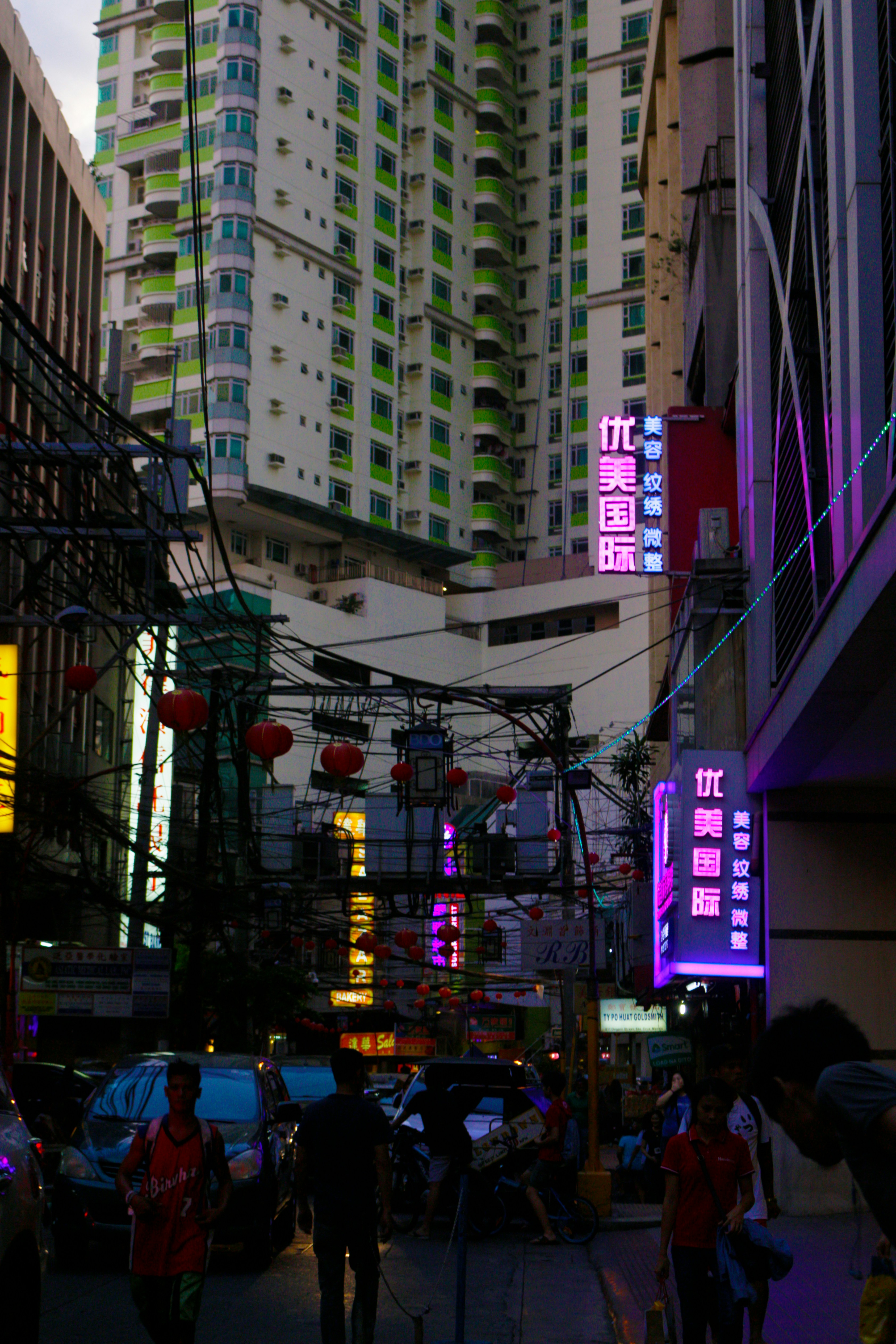 a group of people walking down a street next to tall buildings
