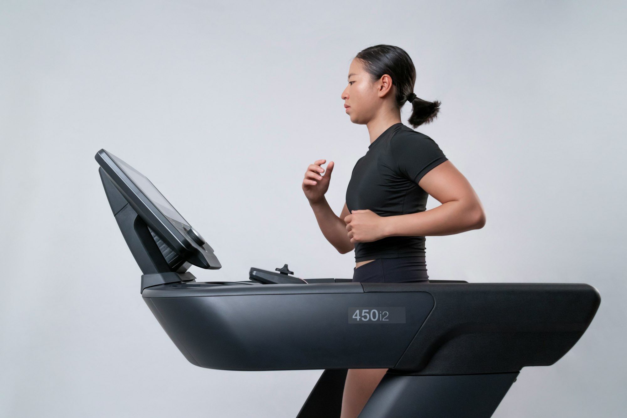 Side view of fit, young woman running on an Intenza 450 Series Treadmill.