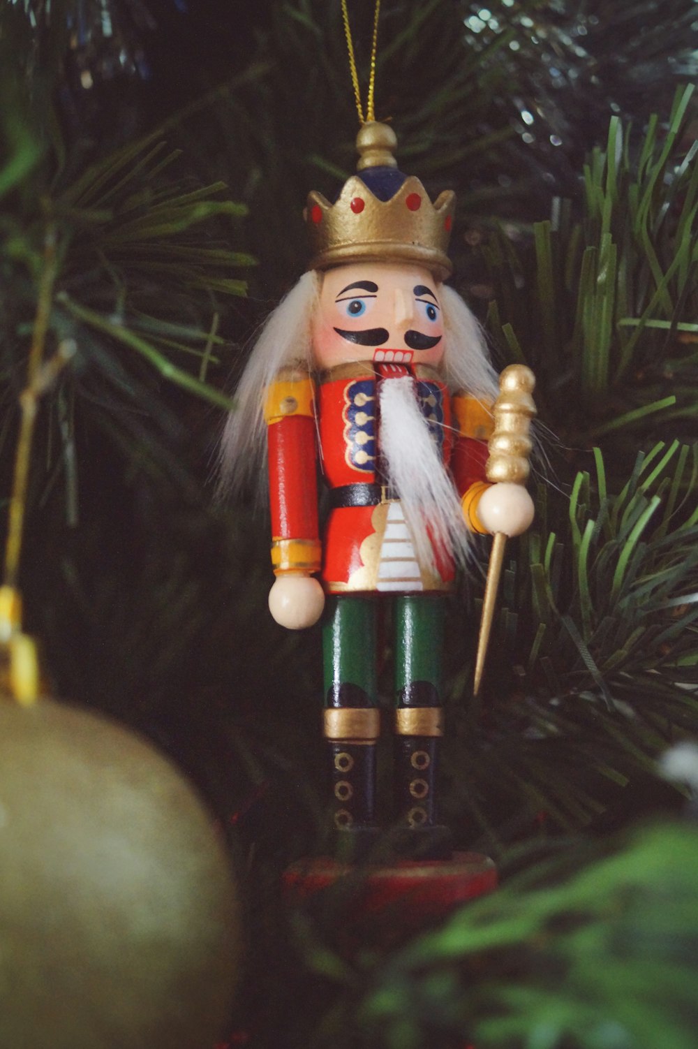 a nutcracker ornament hanging from a christmas tree