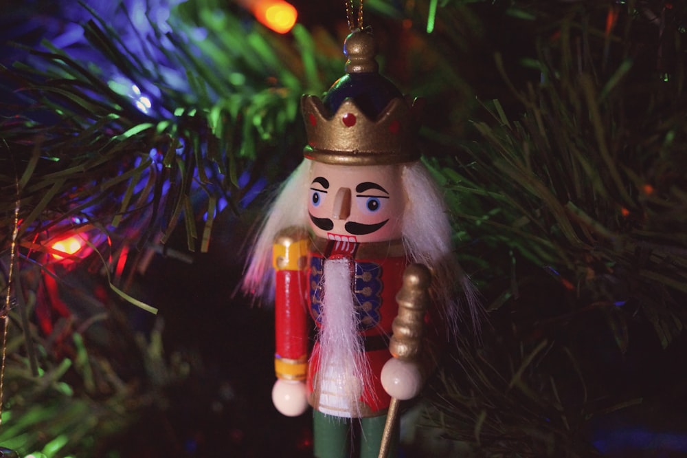 a nutcracker ornament hanging from a christmas tree