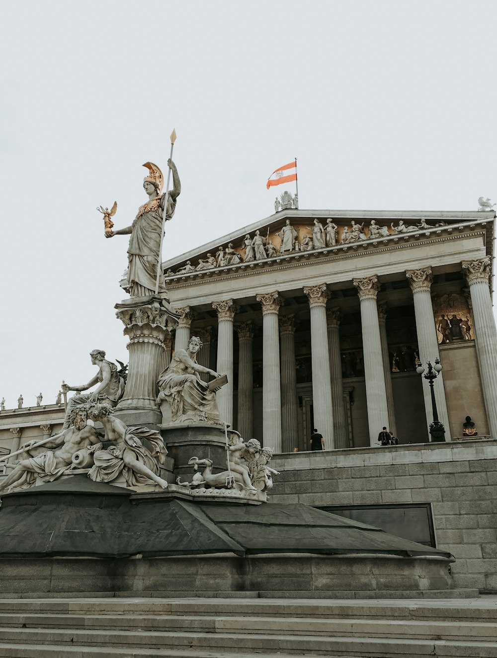 a statue of a woman holding a flag in front of a building