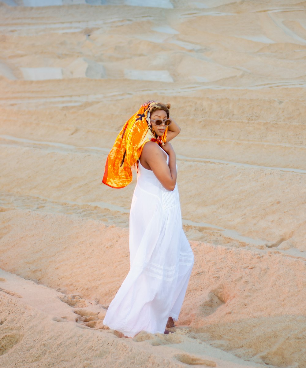 a woman in a white dress talking on a cell phone