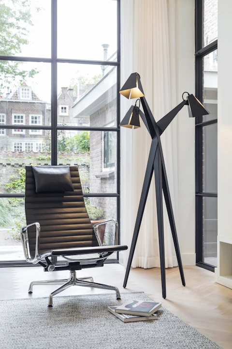 Sculptural floor lamp beside a lounge chair
