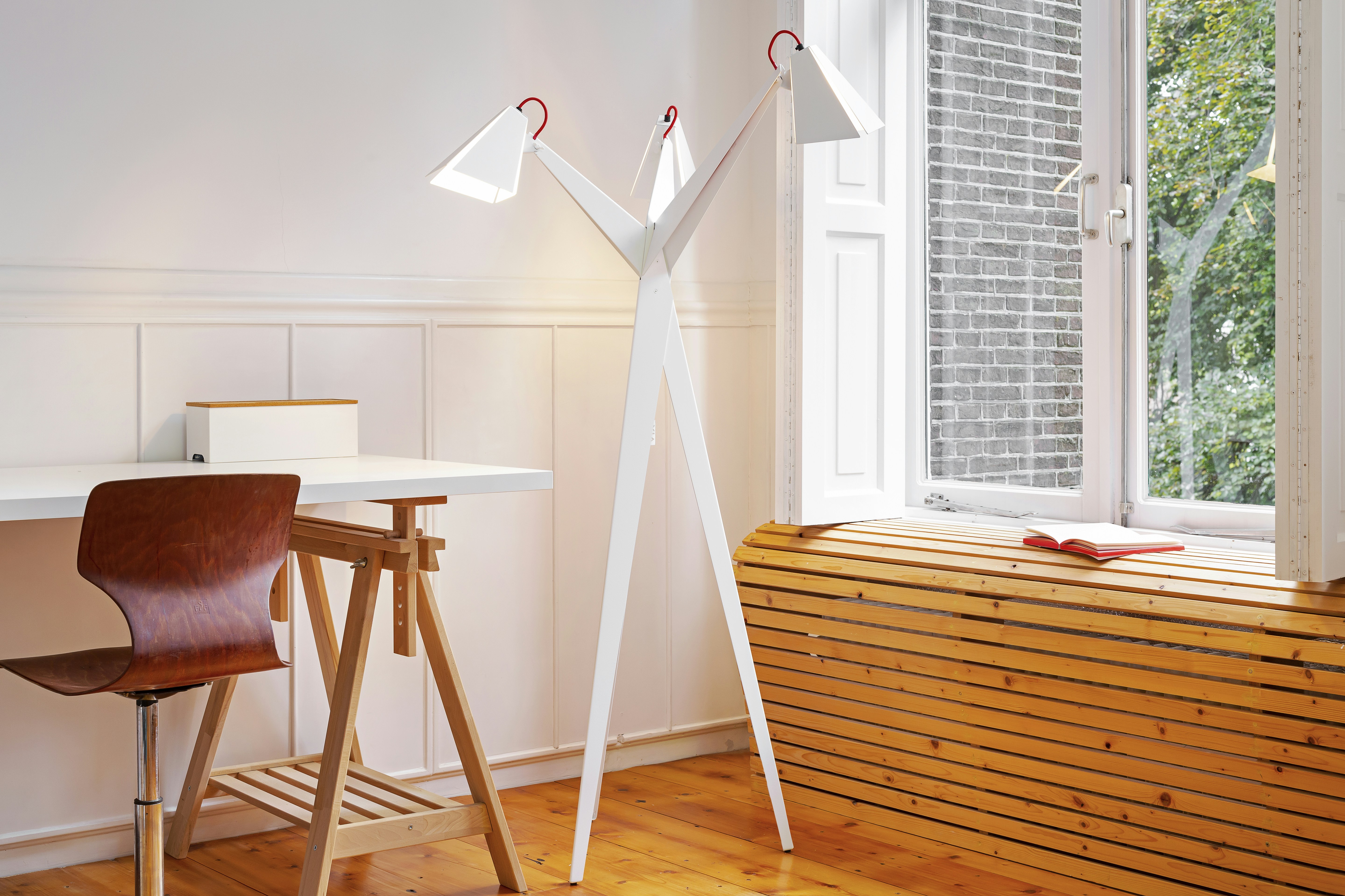 une chambre avec un bureau, une chaise et une lampe