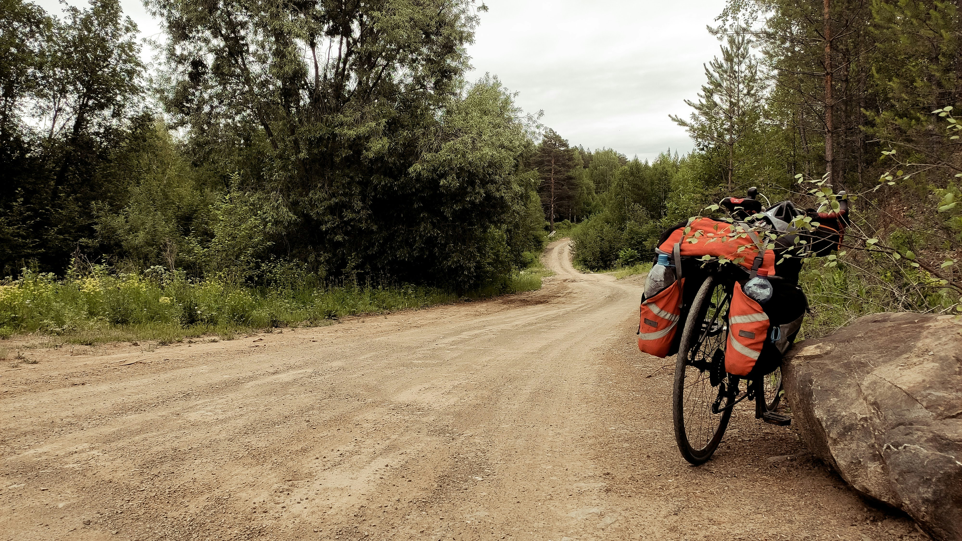 a bike parked on the side of a dirt road