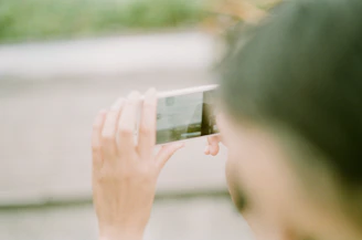 Lifestyle shot of a person using a smartphone outdoors with a blurred background