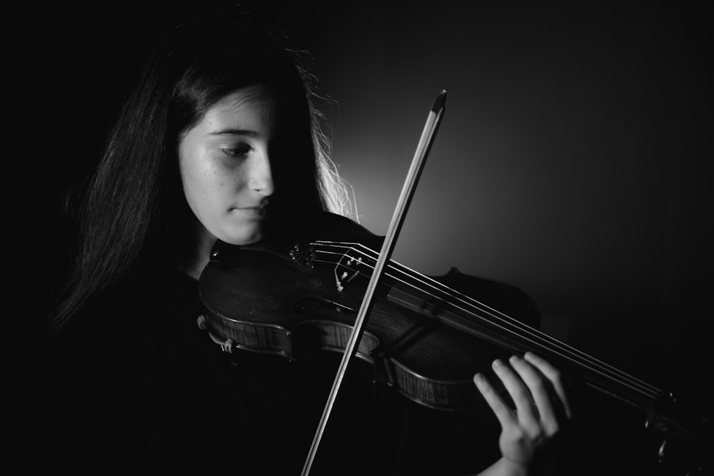 a woman holding a violin in her hands