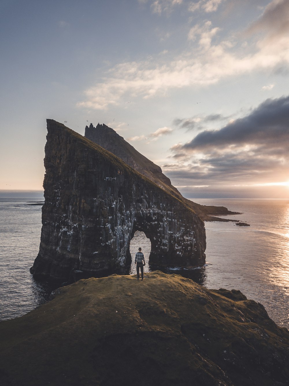 two people standing in front of a large rock formation