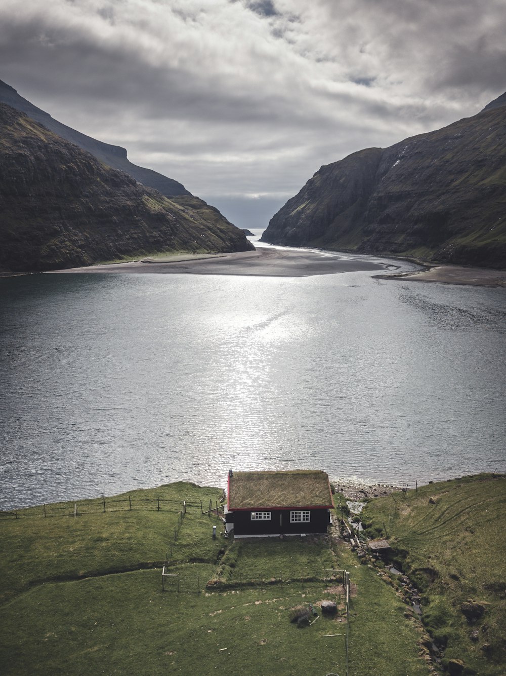 a small house sitting on top of a lush green hillside