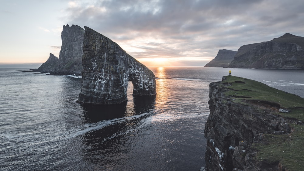 a person standing on the edge of a cliff overlooking the ocean