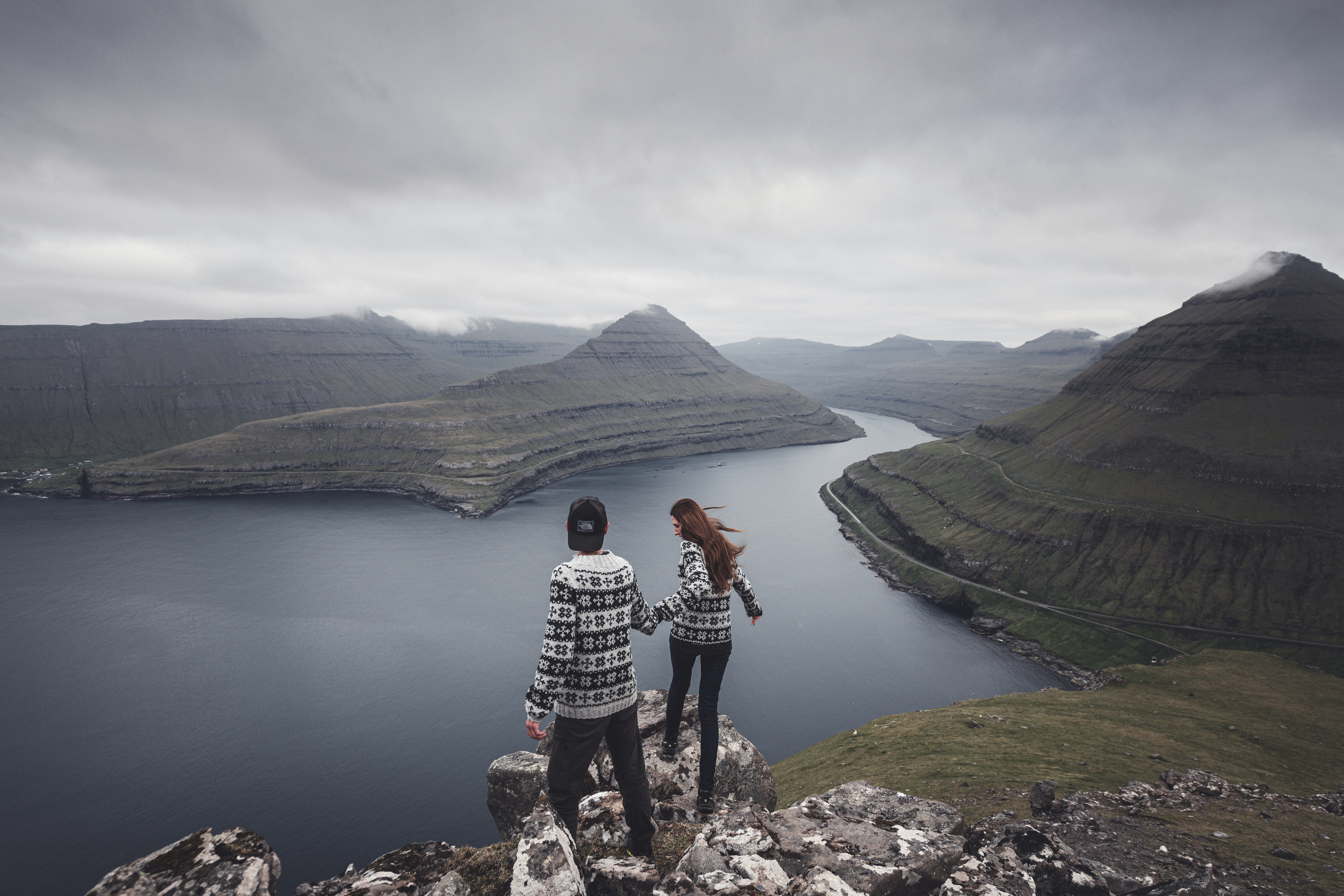 a couple of people standing on top of a mountain