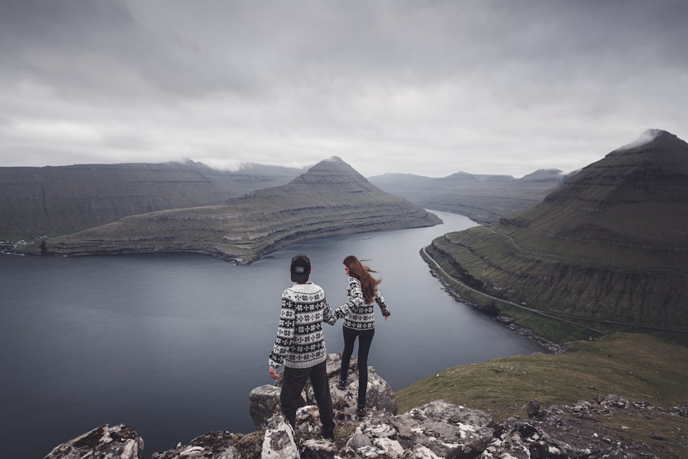 a couple of people standing on top of a mountain