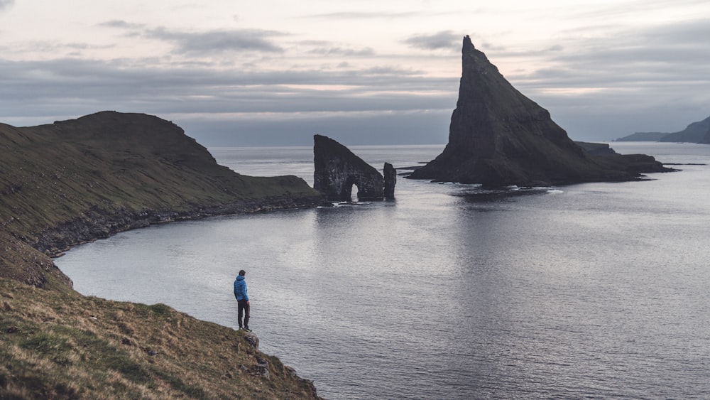 a person standing on a hill overlooking a body of water