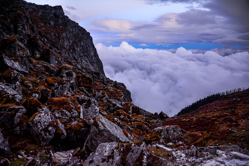 a rocky mountain with low lying clouds in the distance