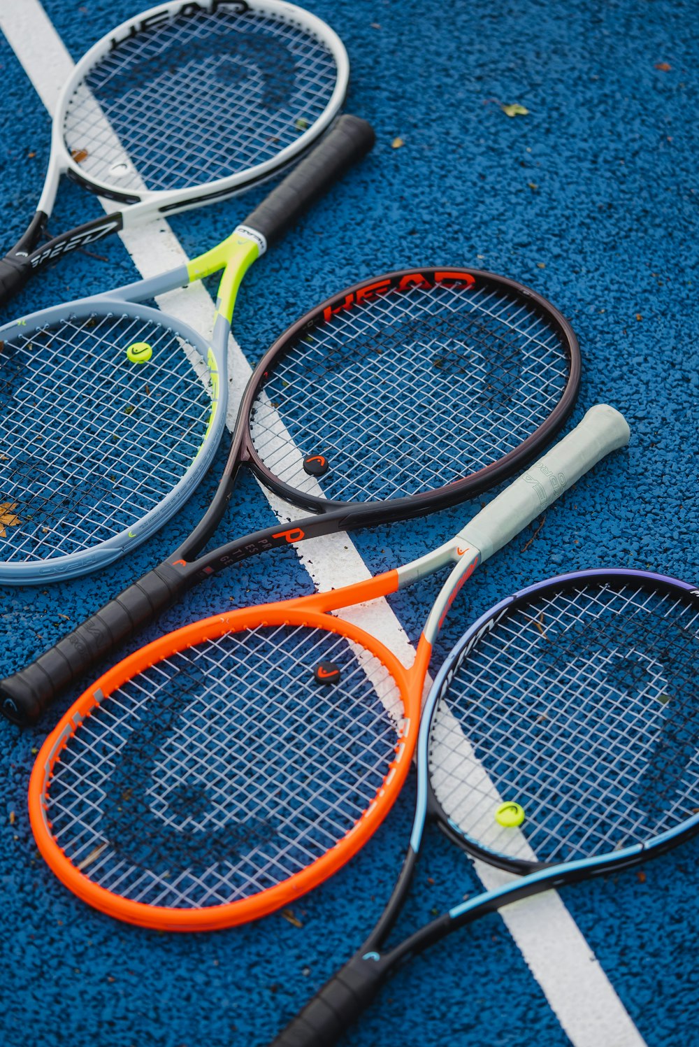 three tennis rackets laying on a tennis court