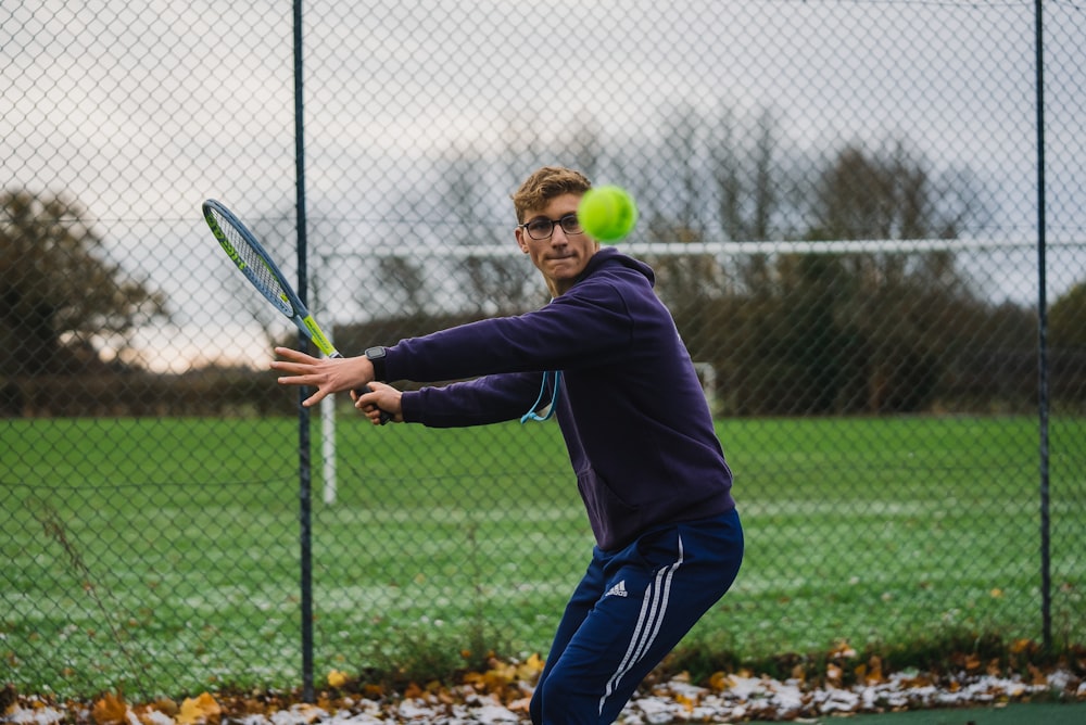 Un uomo che colpisce una pallina da tennis con una racchetta da tennis