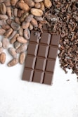 a bar of chocolate next to a pile of nuts