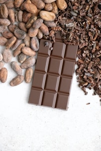 a bar of chocolate next to a pile of nuts