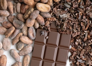 a bar of chocolate next to a pile of nuts