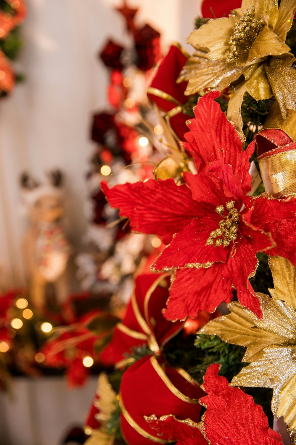 a christmas tree decorated with red and gold poinsettis
