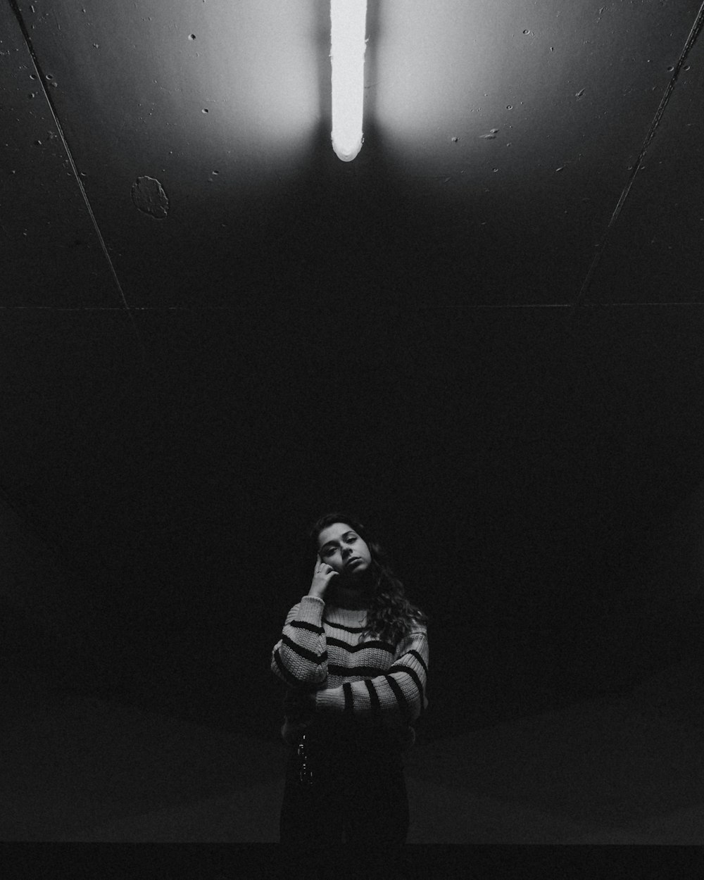 a woman is standing in a dark room