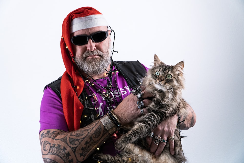 a man in a santa hat holding a cat