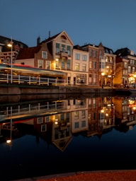 a night scene of a city with a river and buildings