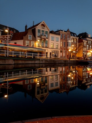 a night scene of a city with a river and buildings