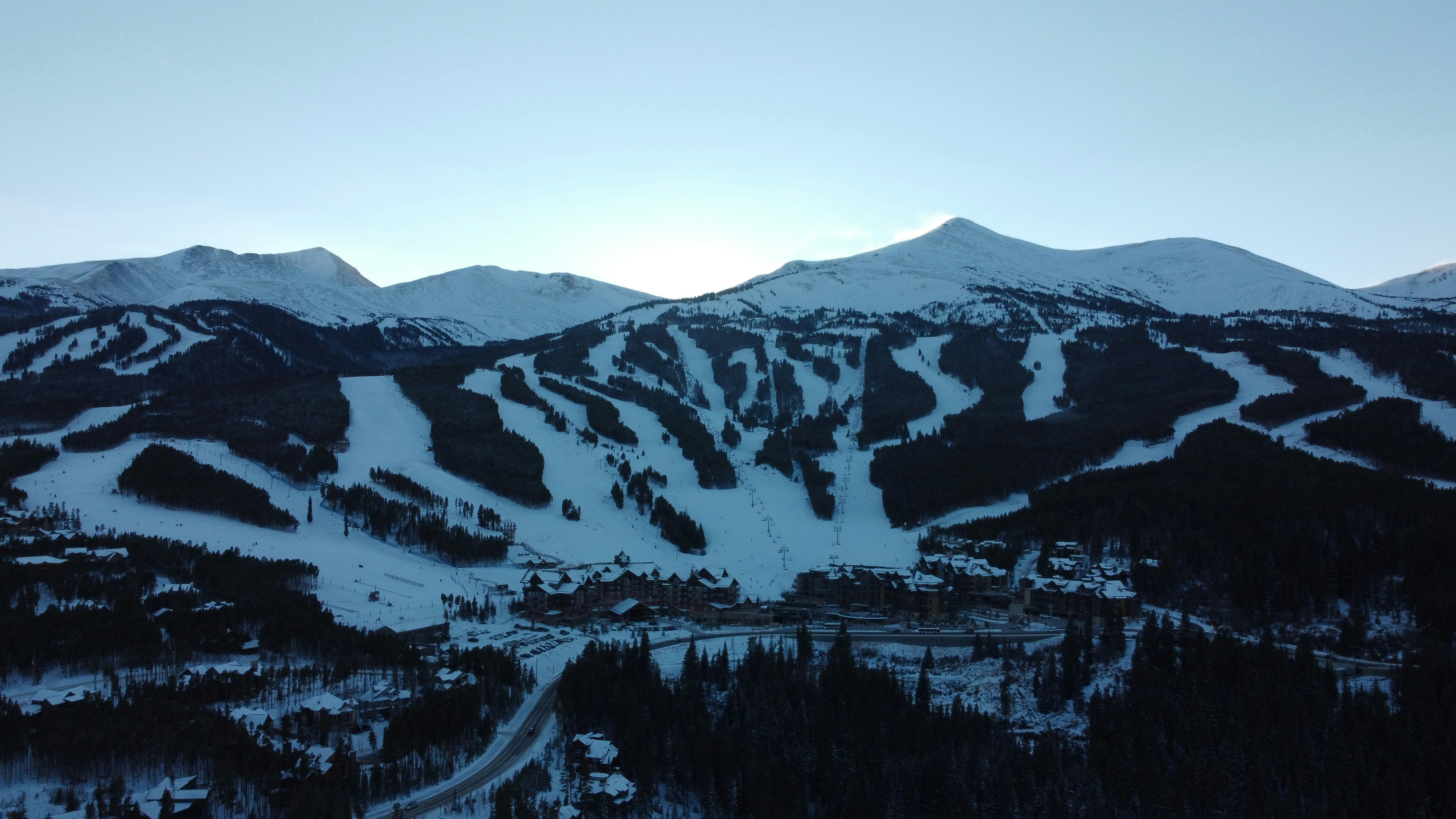 Una montaña cubierta de nieve con una estación de esquí en primer plano
