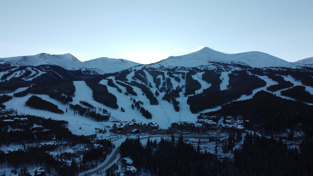 a snow covered mountain with a ski resort in the foreground