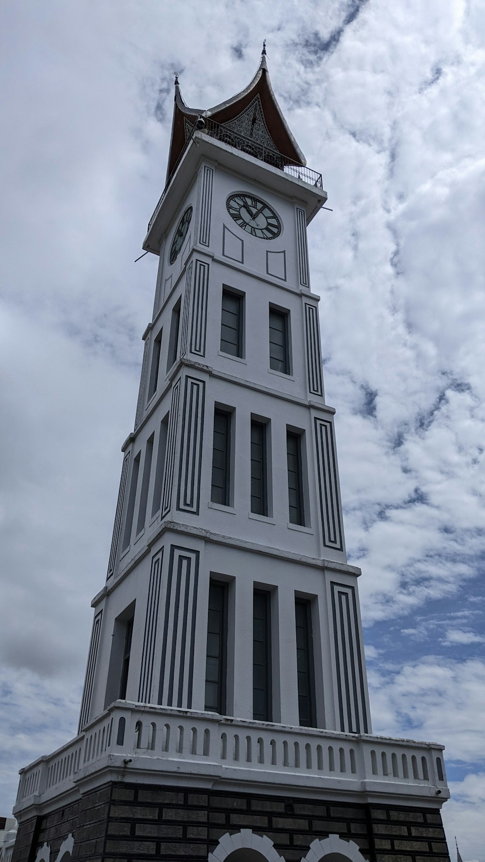 a tall white clock tower with a clock on each of it's sides