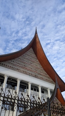 a building with a metal fence and a clock tower in the background