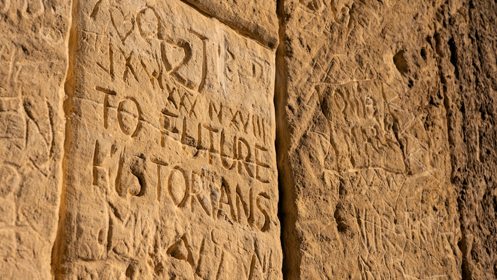 a close up of a stone wall with writing on it