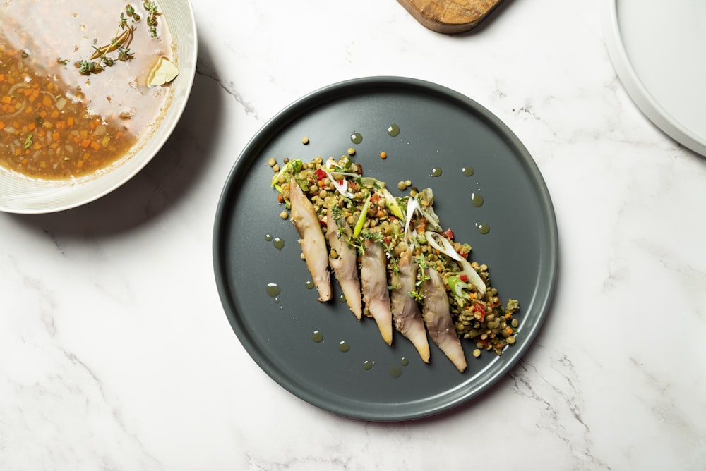 a plate of food on a table next to a bowl of soup