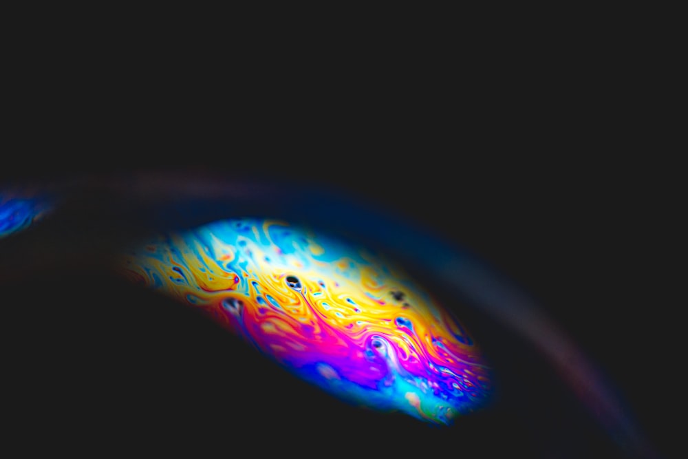 a close up of a colorful object in the dark