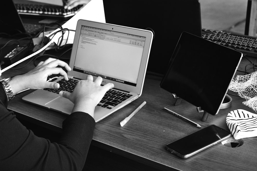 a person sitting at a desk using a laptop computer