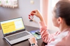 a woman sitting at a desk with a laptop computer