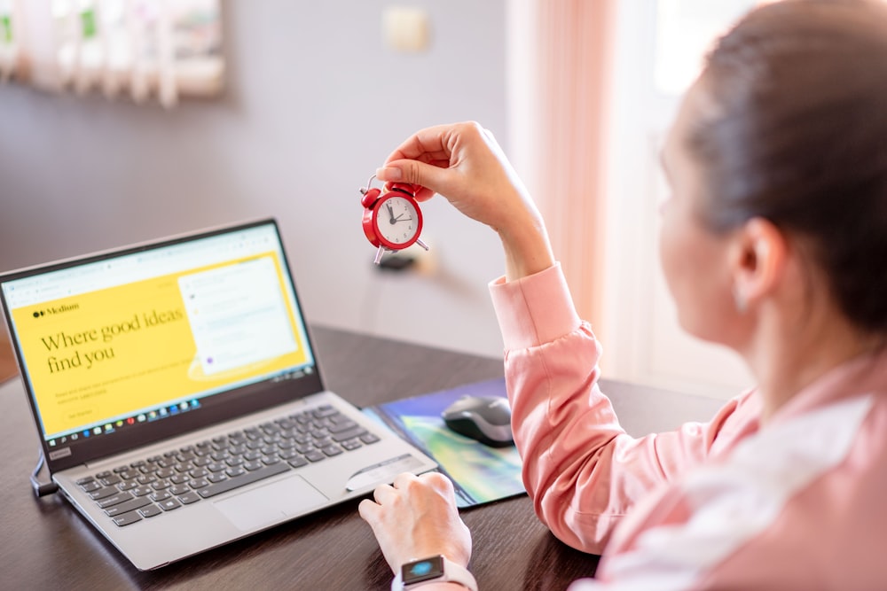 uma mulher sentada em uma mesa com um computador portátil